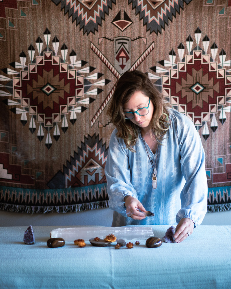 Jenna Lynn preparing crystals and healing stones for a Reiki session at Balance Health Studio